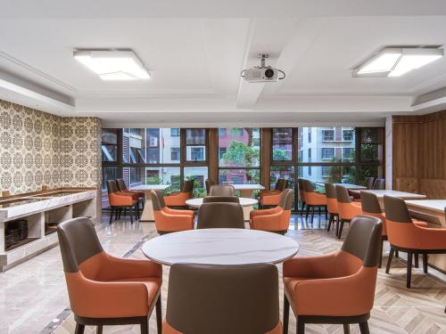 a restaurant with tables and chairs and a fireplace at Vienna International Hotel Zhangjiajie Tianmen Mountain in Zhangjiajie