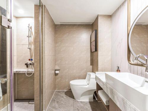 a bathroom with a toilet and a sink and a shower at Vienna International Hotel Zhangjiajie Tianmen Mountain in Zhangjiajie