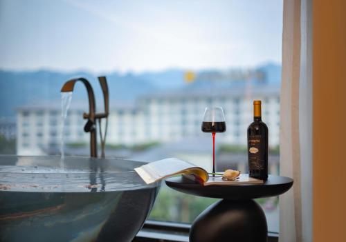 a bottle of wine and a glass on a table at Zhangjiajie Yujie Hotel in Zhangjiajie