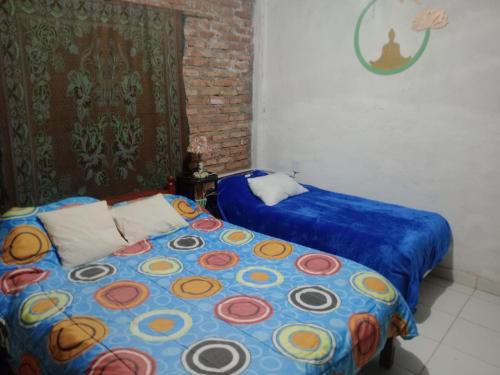 a bedroom with a bed with a blue comforter at Cabaña El Tata in Termas de Río Hondo