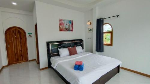a bedroom with a bed with two blue bags on it at Baan Iris Salaya in Salaya