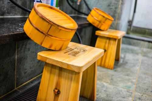a row of wooden benches with buckets on them at SUPERHOTEL Matsumoto Oshiroguchi in Matsumoto