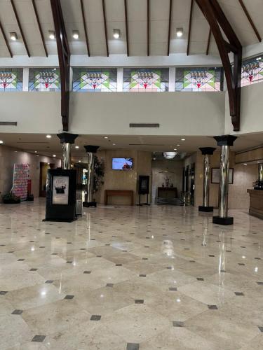 a large room with a tile floor and stained glass windows at Horison Ultima Bandung in Bandung