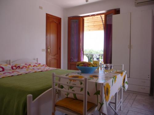 1 dormitorio con 1 cama con mesa y sillas en Le Terrazze, en Lipari