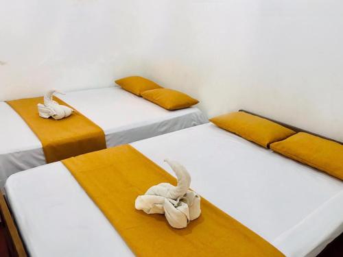 a room with three beds with stuffed animals on them at Better Holiday Resort in Deniyaya