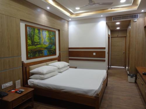 a bedroom with a bed and a painting on the wall at Indo Hokke Hotel in Rājgīr