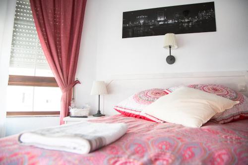 a bedroom with a bed with pillows and a window at Alojamiento Miramar in Santoña