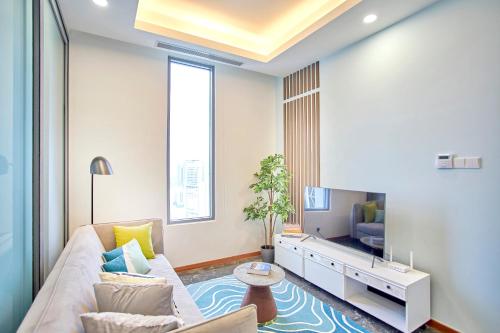 a living room with a couch and a tv at Royce Residence KLCC by Cobnb in Kuala Lumpur