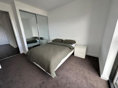 a bedroom with a bed and a mirror at Magnificent Apartment with Views and Pool in Blackburn