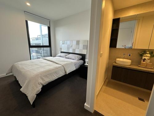 a bedroom with a large bed and a sink at Magnificent Apartment with Views and Pool in Blackburn