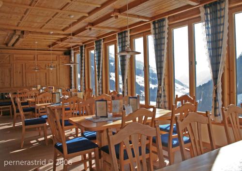 a dining room with tables and chairs and windows at Gast- und Ferienhof Christler in Tux