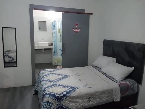 a bedroom with a bed and a bathroom with a sink at Barato seguro y cómodo, Anclas in Manzanillo