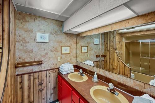 une salle de bain avec deux lavabos et un grand miroir dans l'établissement Stairway to Heaven at Rockaway, à Rockaway Beach