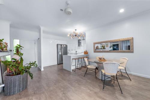 Una cocina y un comedor con mesa y sillas. en Ocean's Edge, en Cannonvale
