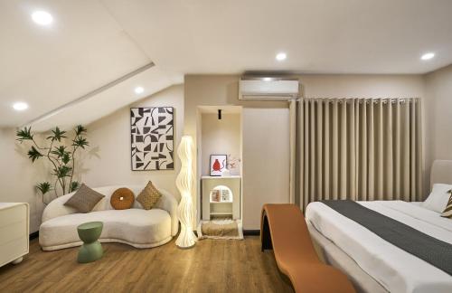 a bedroom with two beds and a couch in it at Cloud Passion Airport Hotel in Ho Chi Minh City