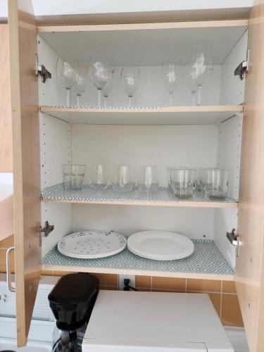 a cupboard with plates and bowls and glasses at Downtown Toronto Cozy Suite in Toronto