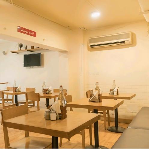 a restaurant with tables and chairs and a tv at Hotel Platinum With Free Pickup-Delhi Airport in New Delhi