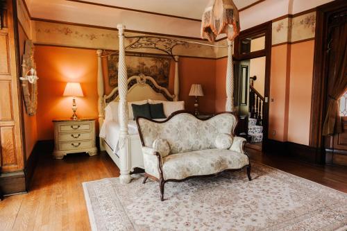 a bedroom with a canopy bed and a chair at Villagio Boutique Hotel in Pittsburgh