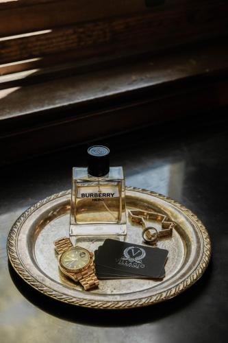 a bottle of perfume and a watch on a plate at Villagio Boutique Hotel in Pittsburgh