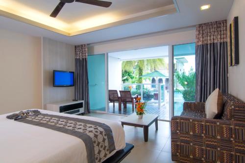 a hotel room with a bed and a balcony at Anyavee Tubkaek Beach Resort in Tab Kaek Beach