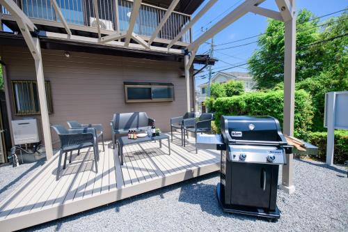 a barbecue on a patio with chairs and a table at Guest Villa Hakone Sengokuhara Kintoki - ゲストヴィラ箱根仙石原金時 in Hakone