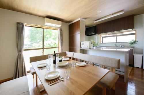a dining room and kitchen with a wooden table and chairs at Guest Villa Hakone Sengokuhara Kintoki - ゲストヴィラ箱根仙石原金時 in Hakone