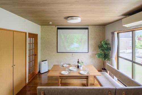 a dining room with a wooden table and a large window at Guest Villa Hakone Sengokuhara Kintoki - ゲストヴィラ箱根仙石原金時 in Hakone
