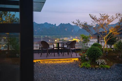 a table and chairs on a balcony with a view at Zhangjiajie Yujie Hotel in Zhangjiajie