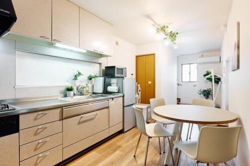 a kitchen with a table and a small table and chairs at Oneness House Kumamoto in Kumamoto