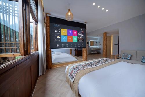 a bedroom with a large screen on the wall at Shanyeji Garden Resort Panorama Hotel in Xinping