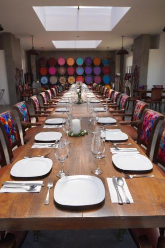 a long wooden table with plates and silverware on it at Estancias Sierravita in Valle de Guadalupe