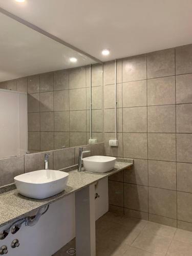 a bathroom with two sinks and a large mirror at Guanaco Hostel in Puerto Madryn