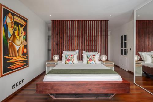 a bedroom with a large bed in a room at JADE - Villa Créole de Standing et de charme ,vue mer , proche des plages & piscine privée haut de gamme in Saint-François