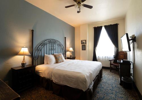 a bedroom with a large bed and a ceiling fan at The Holland Hotel in Alpine