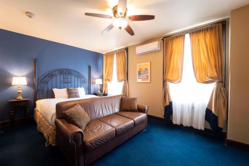 a bedroom with a bed and a couch at The Holland Hotel in Alpine