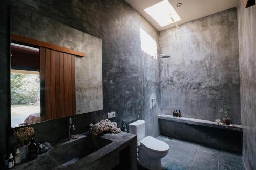 a bathroom with a sink and a toilet and a tub at Tropical Escape 2min Walk to Beach and Private Pool in Cemagi