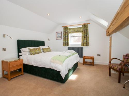 a bedroom with a large bed and a window at Sylva Cottage in Shrewsbury