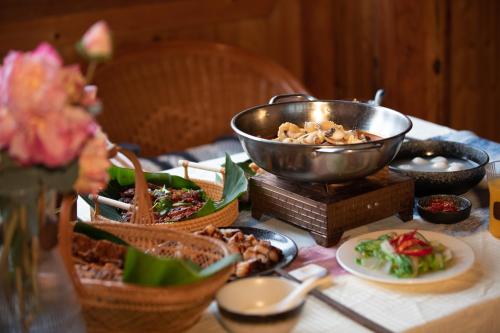 a table topped with bowls and plates of food at Shanyeji Garden Resort Panorama Hotel in Xinping