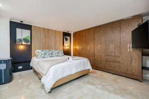Un dormitorio con una cama grande y armarios de madera. en Urban 3rd floor Condo 3bed3bath 6guest max no elevator, en Envigado