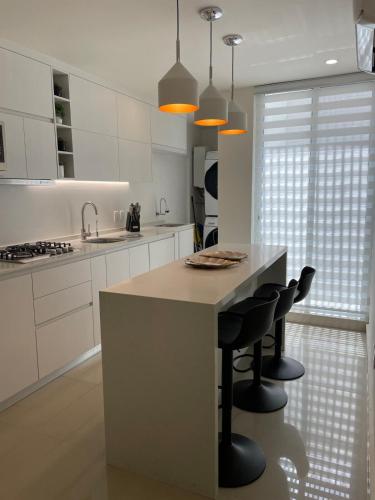 a kitchen with a island with black bar stools at Excellent apartment in Chapalita, everything new in Guadalajara