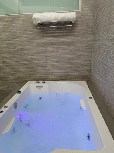 a bath tub with blue water in a bathroom at Excellent apartment in Chapalita, everything new in Guadalajara