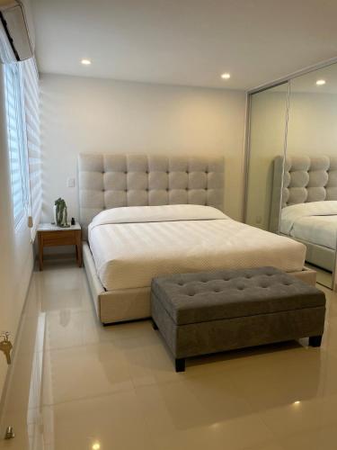 a bedroom with a large bed with a tufted headboard at Excellent apartment in Chapalita, everything new in Guadalajara