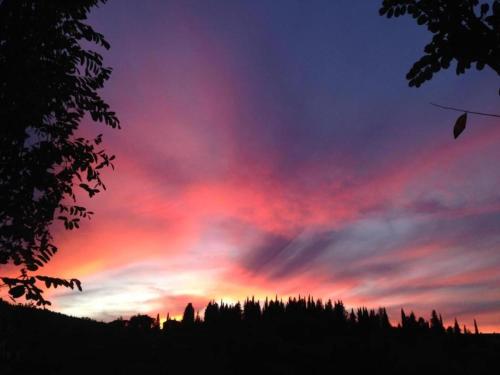 a colorful sky with trees in the foreground at Apartment in Umbria near Lake Trasimeno in Mantignana