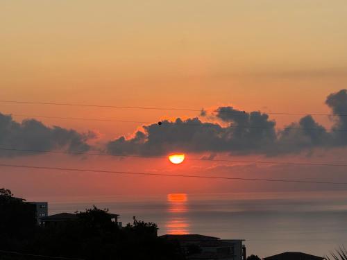un coucher de soleil sur une masse d'eau avec des nuages dans l'établissement Studio A Palma, à Bastia
