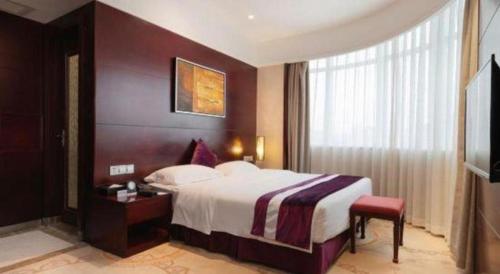 a hotel room with a large bed and a window at Fuzhou Xin Zi Yang Hotel in Fuzhou