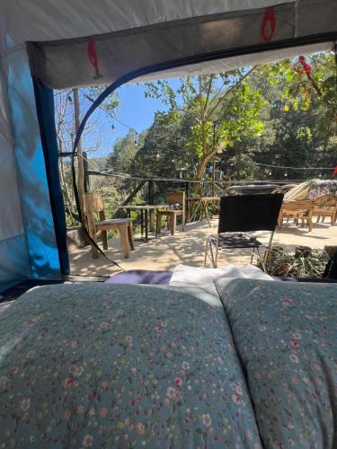 a bed in a tent with a view of a patio at The Sound Of Silence Homestay Đà Lạt in Da Lat
