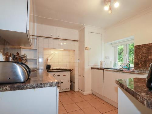 a kitchen with white cabinets and a counter top at Nanvivian in Feock