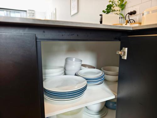 a cabinet filled with blue and white plates and bowls at Walk to Stadium CBD 2BR 2Bath Free Reserved Parking - JJHome in Christchurch