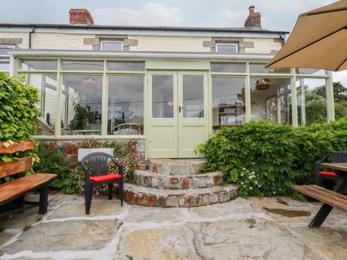 a conservatory with glass doors and stairs in front at Nanvivian in Feock