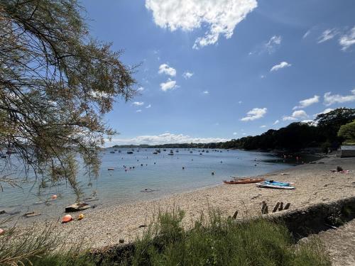 a beach with a bunch of people in the water at Nanvivian in Feock